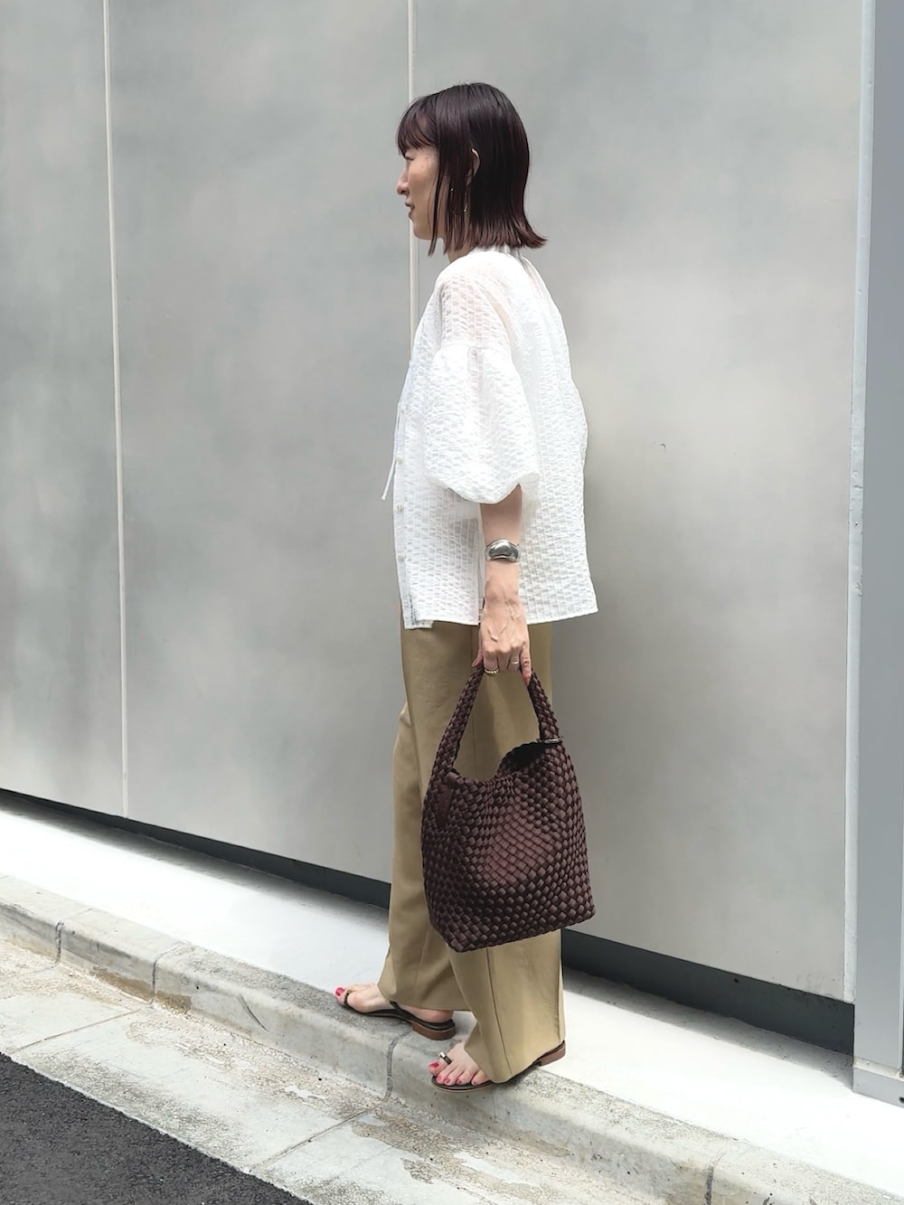 イエロー系のその他パンツ、ホワイト系のタンクトップ、ブラウン系のショルダーバッグを着用したレディースの夏コーディネートの7枚目の写真