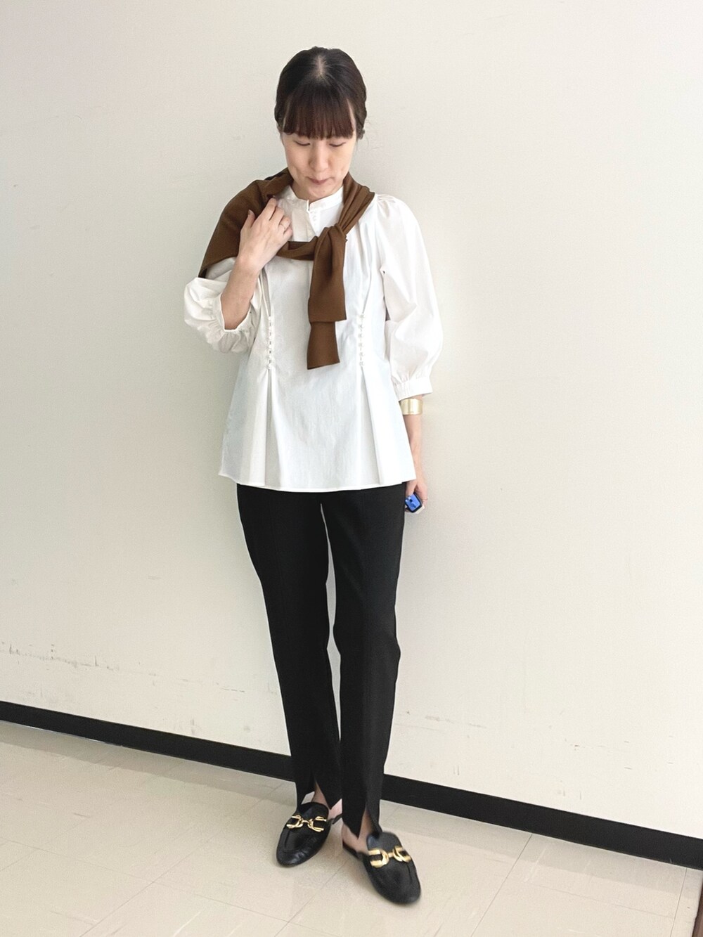 ブラック系のその他パンツ、ブルー系のショルダーバッグ、ホワイト系のシャツ/ブラウスを着用したレディースの秋コーディネートの3枚目の写真