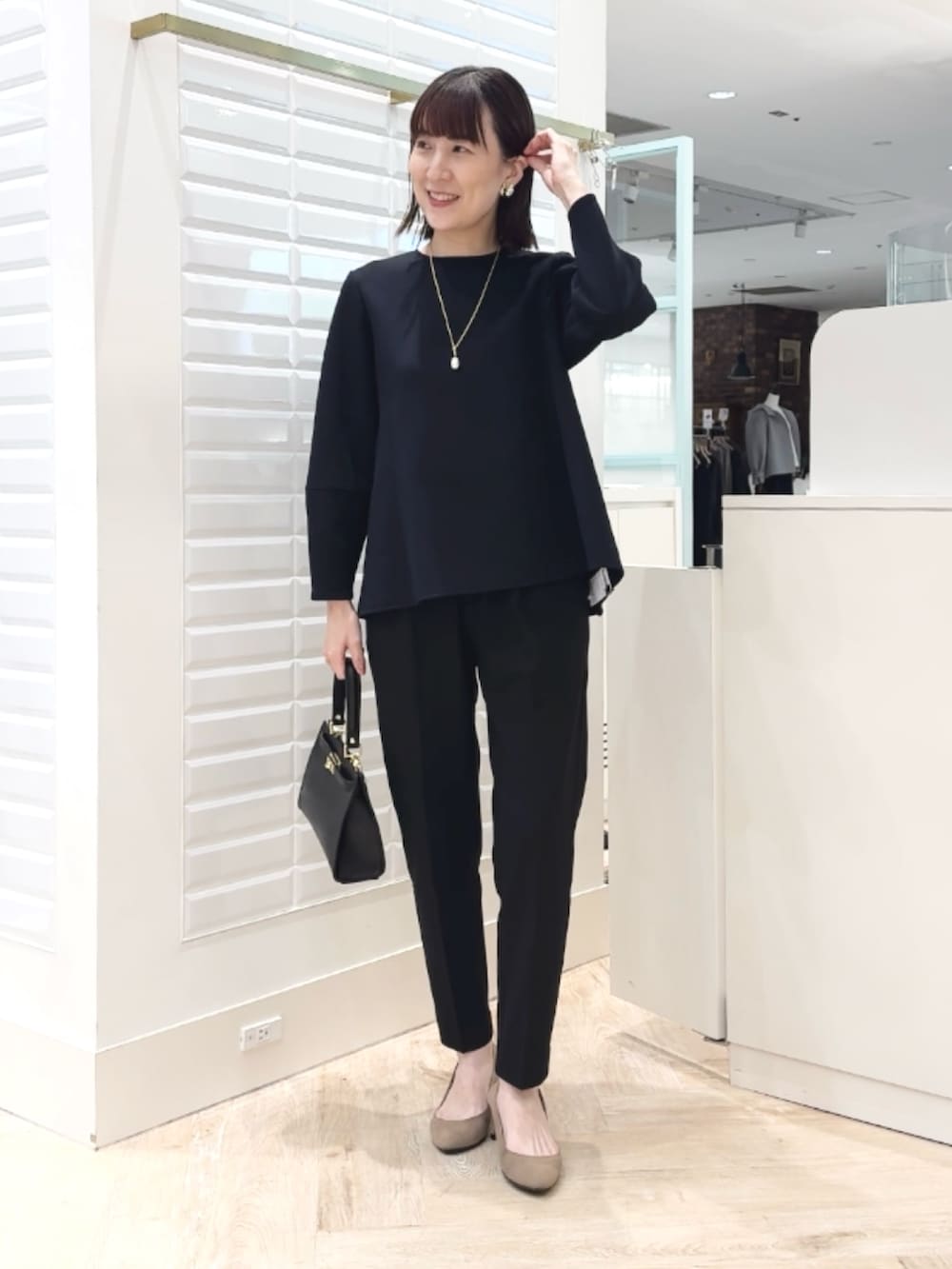 ブラック系のショルダーバッグ、ブラック系のその他パンツ、ブラック系のTシャツ/カットソーを着用したレディースの冬コーディネートの4枚目の写真