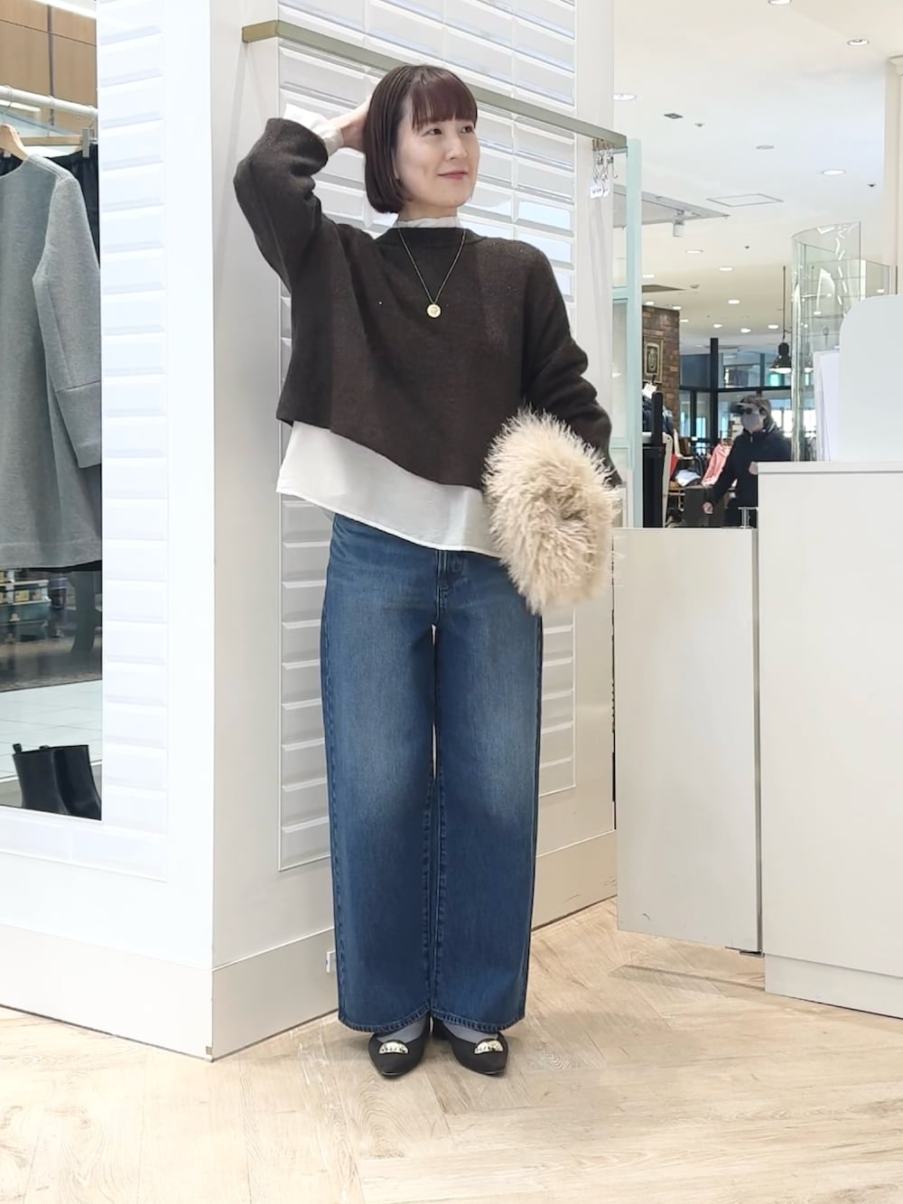 ベージュ系のショルダーバッグ、ホワイト系のシャツ/ブラウス、ブラウン系のニット/セーターを着用したレディースの冬コーディネートの2枚目の写真