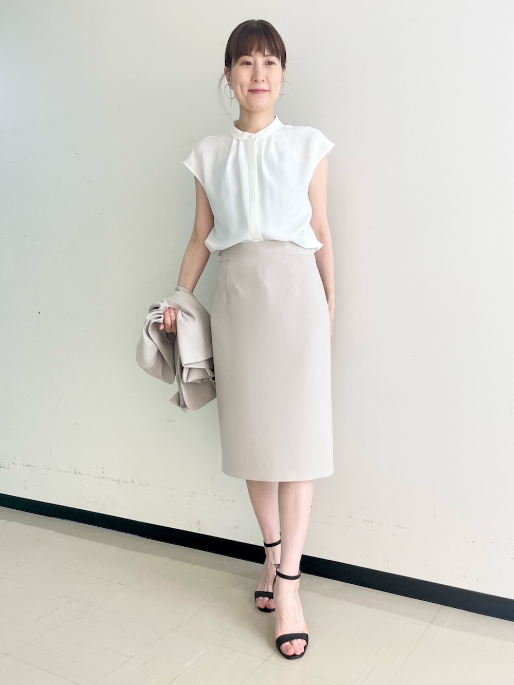 ベージュ系のスカート、ホワイト系のシャツ/ブラウス、ベージュ系のノーカラージャケットを着用したレディースの春コーディネートの7枚目の写真