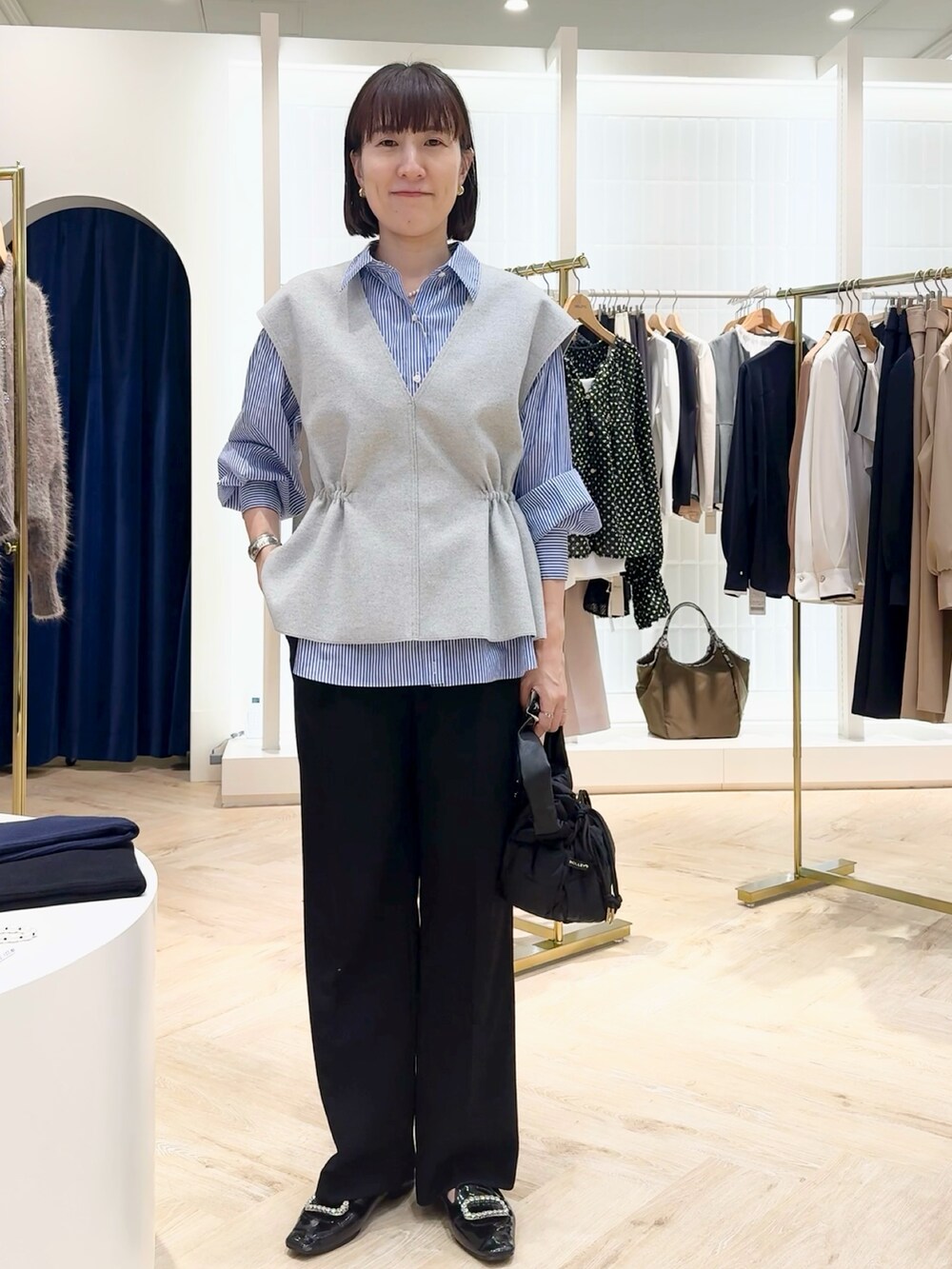 ブルー系のその他パンツ、グレー系のベスト、ブルー系のシャツ/ブラウスを着用したレディースの秋コーディネートの7枚目の写真