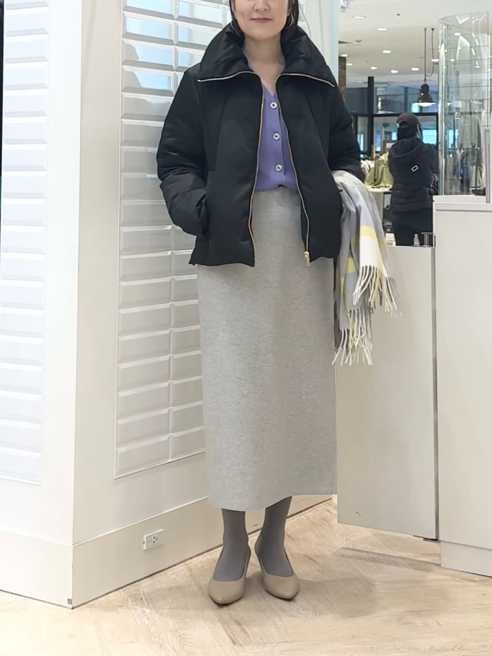ブラック系のダウンジャケット/コート、パープル系のカーディガン/ボレロ、グレー系のスカートを着用したレディースの秋コーディネートの8枚目の写真