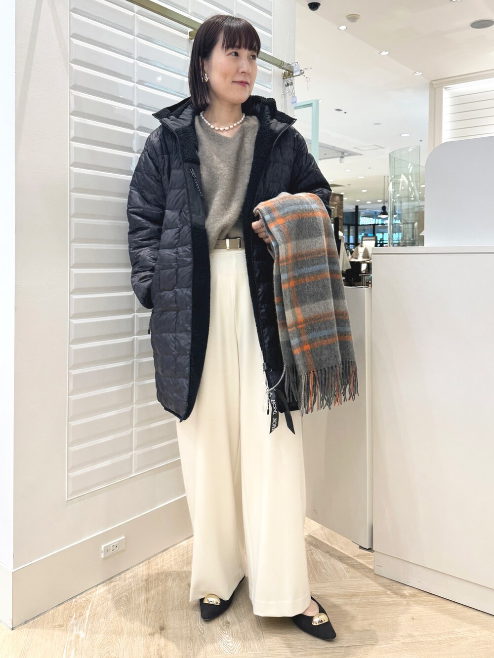 ホワイト系のその他パンツ、ベージュ系のトートバッグ、ブラック系のダウンジャケット/コートを着用したレディースの秋コーディネートの9枚目の写真