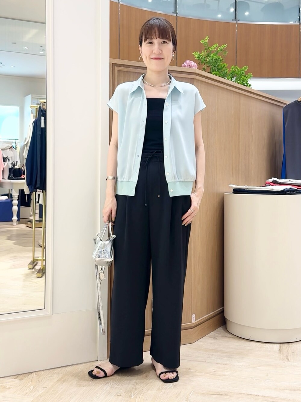 シルバー系のショルダーバッグ、ブラック系のその他パンツ、グリーン系のシャツ/ブラウスを着用したレディースの夏コーディネートの8枚目の写真