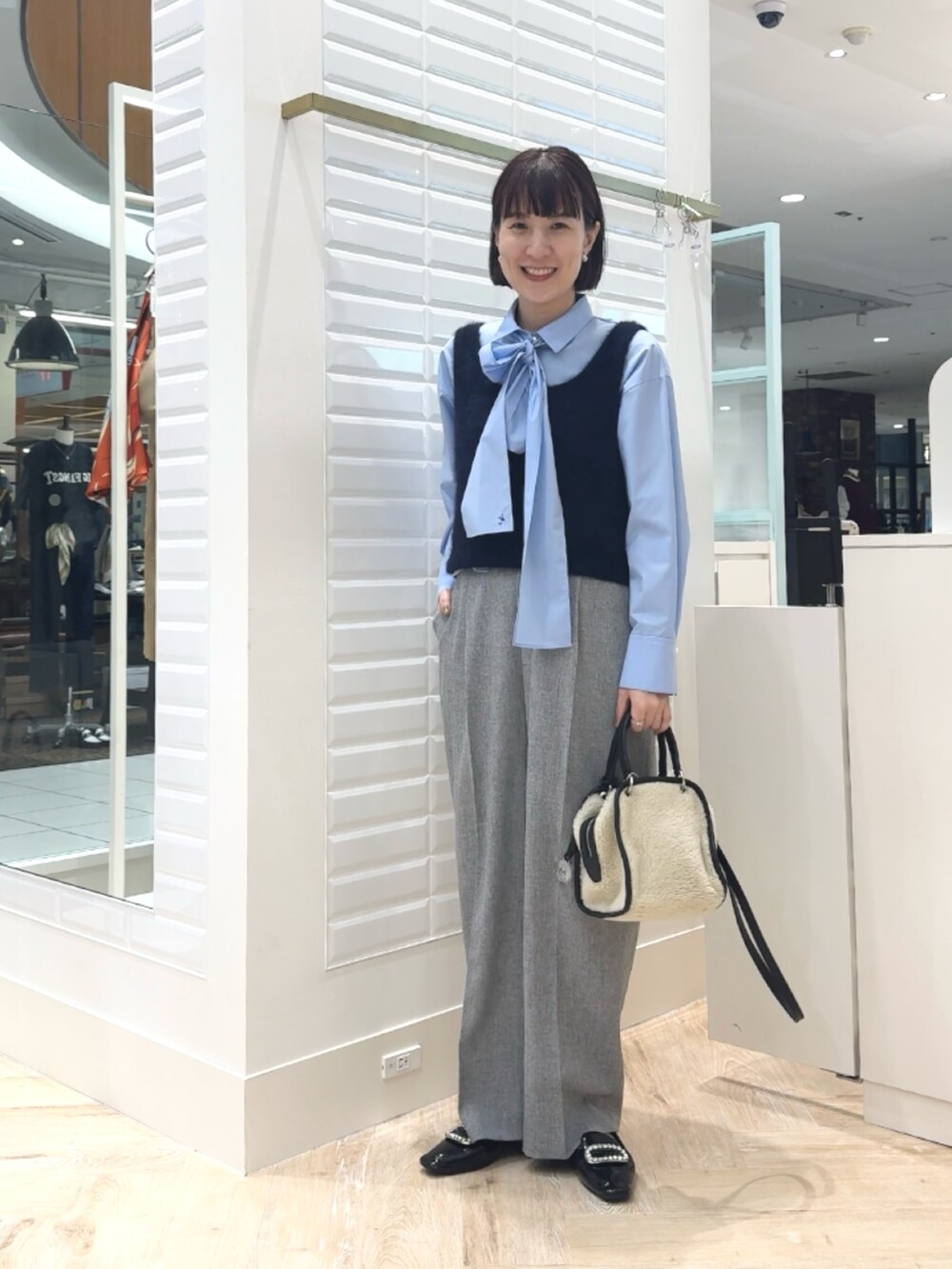 ホワイト系のボストンバッグ、ブルー系のベスト、ブルー系のシャツ/ブラウスを着用したレディースの秋コーディネートの10枚目の写真