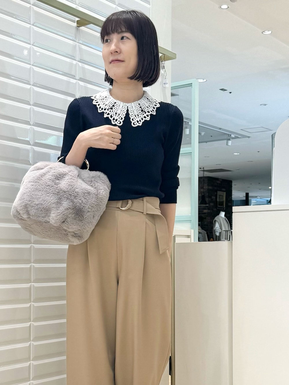 ベージュ系のその他パンツ、グレー系のショルダーバッグ、ブルー系のニット/セーターを着用したレディースの秋コーディネートの3枚目の写真