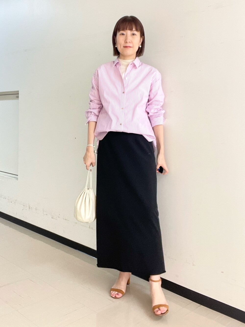 ブラック系のスカート、ホワイト系のニット/セーター、ピンク系のシャツ/ブラウスを着用したレディースの冬コーディネートの5枚目の写真