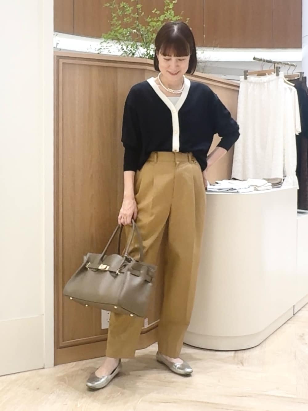 ブルー系のカーディガン/ボレロ、イエロー系のその他パンツ、ベージュ系のトートバッグを着用したレディースの秋コーディネートの4枚目の写真