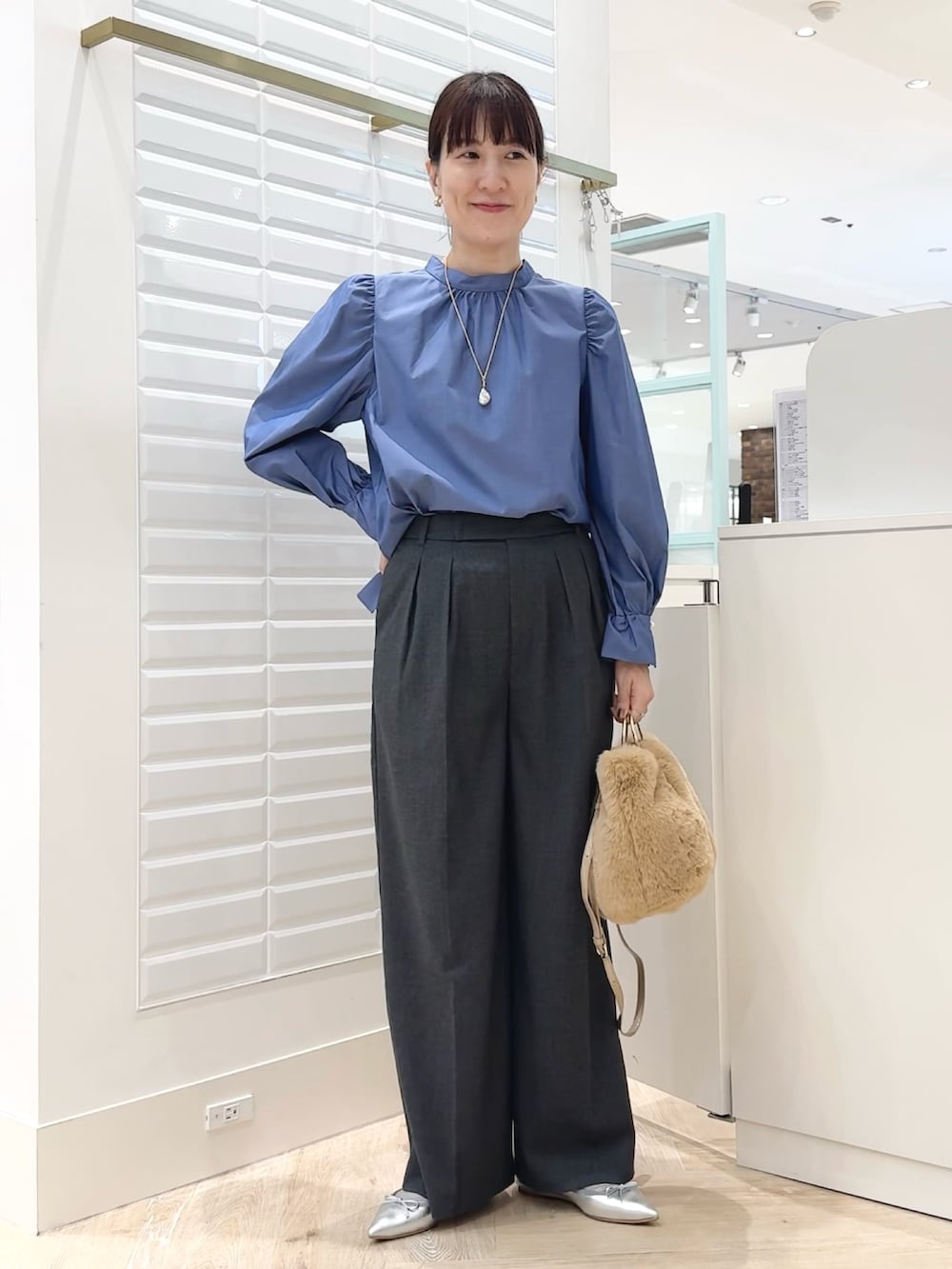 ブルー系のシャツ/ブラウス、ベージュ系のショルダーバッグ、グレー系のその他パンツを着用したレディースの秋コーディネートの4枚目の写真