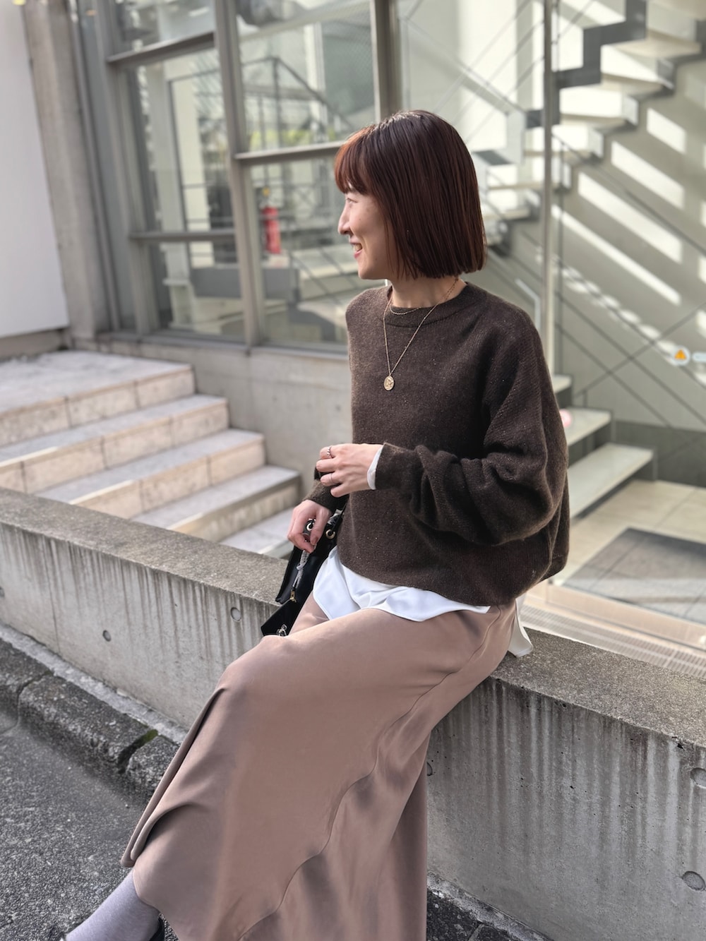 ホワイト系のシャツ/ブラウス、ブラウン系のニット/セーター、ブラック系のその他シューズを着用したレディースの冬コーディネートの7枚目の写真