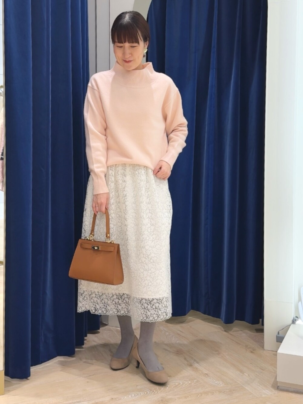 ピンク系のニット/セーター、イエロー系のショルダーバッグ、ホワイト系のスカートを着用したレディースの冬コーディネートの8枚目の写真