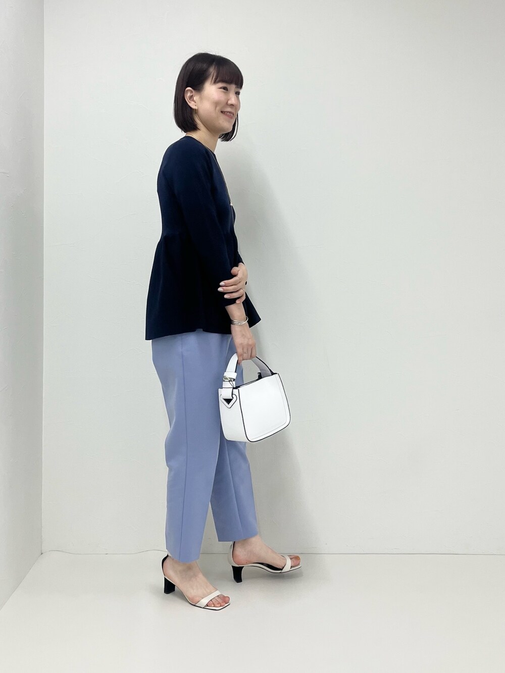 ブルー系のその他パンツ、ホワイト系のショルダーバッグ、ブルー系のニット/セーターを着用したレディースの冬コーディネートの2枚目の写真