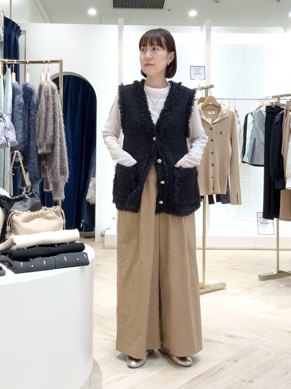 イエロー系のその他パンツ、ブルー系のベスト、ベージュ系のTシャツ/カットソーを着用したレディースの秋コーディネートの6枚目の写真