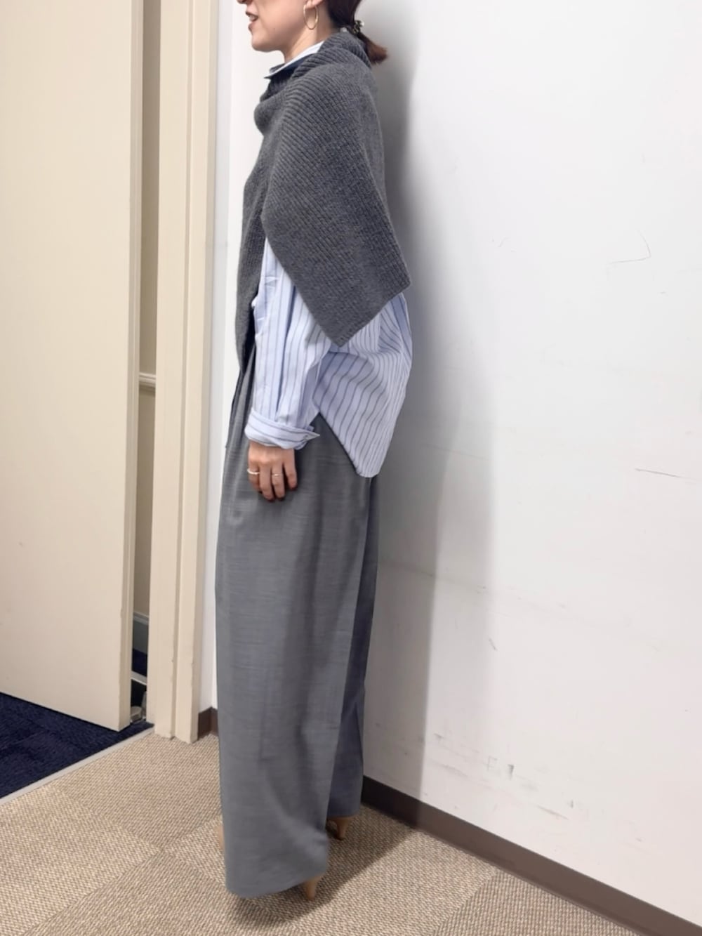 グレー系のニット/セーター、グレー系のその他パンツ、ブルー系のシャツ/ブラウスを着用したレディースの秋コーディネートの9枚目の写真