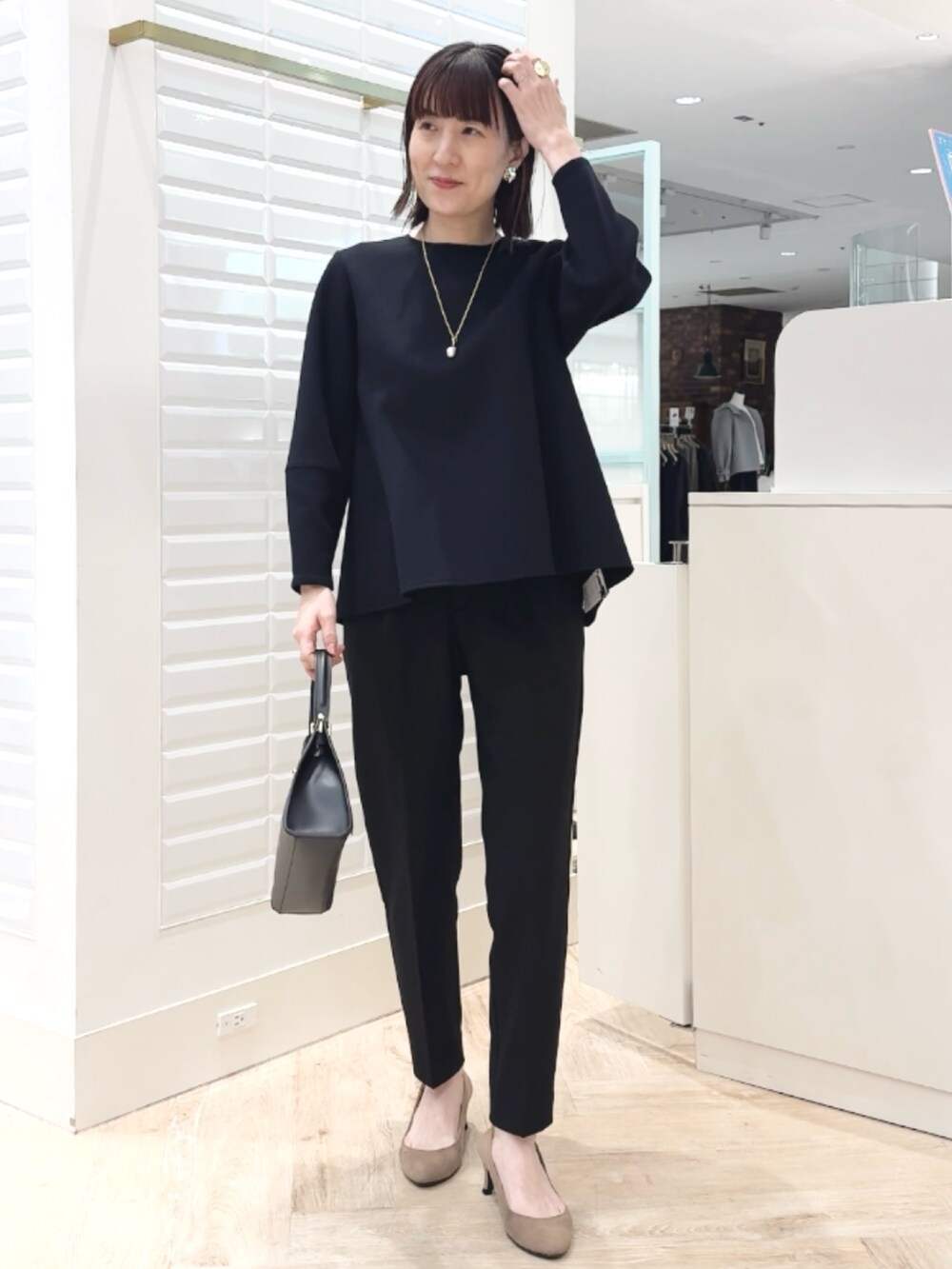 ブラック系のショルダーバッグ、ブラック系のその他パンツ、ブラック系のTシャツ/カットソーを着用したレディースの冬コーディネートの10枚目の写真