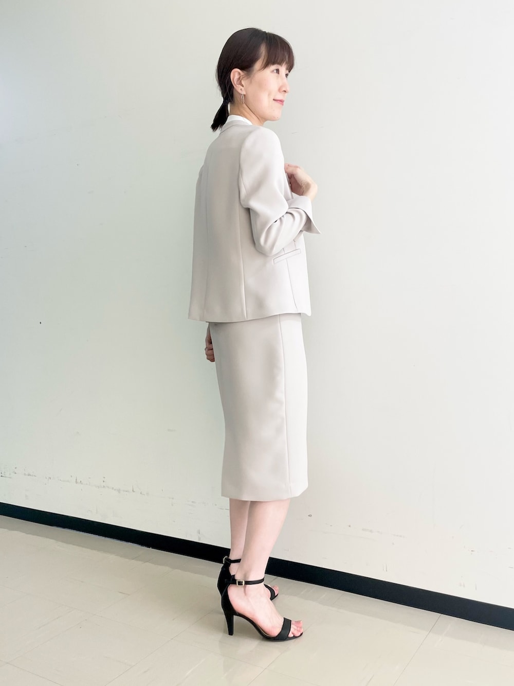 ベージュ系のスカート、ホワイト系のシャツ/ブラウス、ベージュ系のノーカラージャケットを着用したレディースの春コーディネートの3枚目の写真