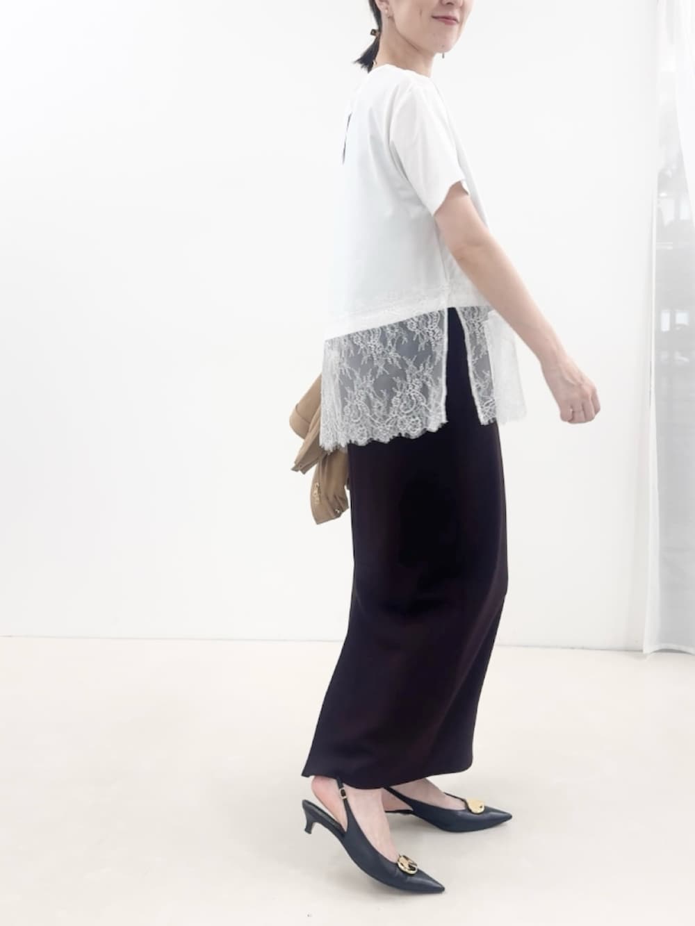 ブラウン系のスカート、ブラック系のパンプス、イエロー系のブルゾンを着用したレディースの秋コーディネートの3枚目の写真