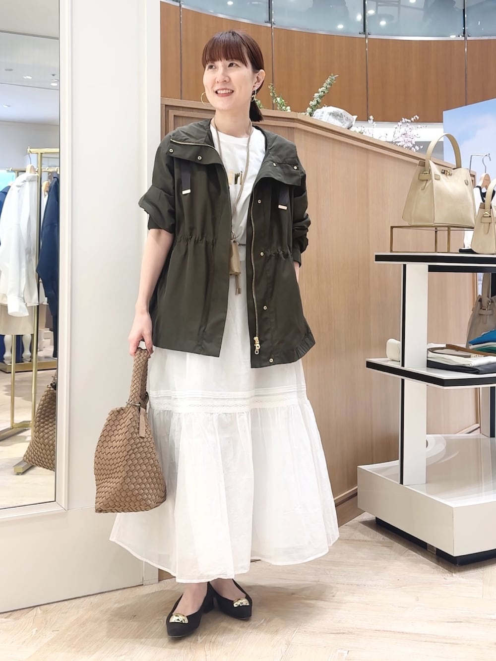 ブラウン系のショルダーバッグ、グレー系のブルゾン、ホワイト系のTシャツ/カットソーを着用したレディースの春コーディネートの7枚目の写真