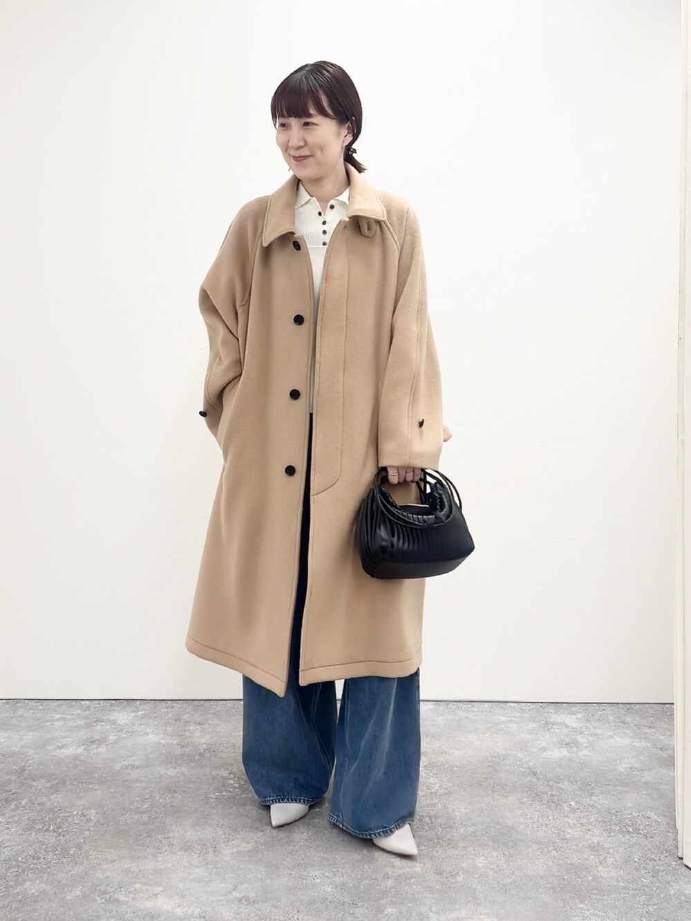 ブルー系のデニムパンツ、ホワイト系のカーディガン/ボレロ、イエロー系のトレンチコートを着用したレディースの夏コーディネートの5枚目の写真