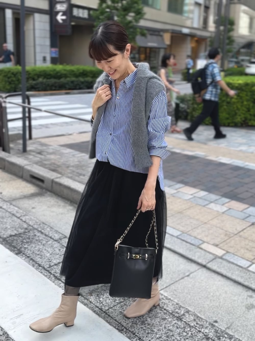 ブラック系のワンピース、ブラック系のショルダーバッグ、ブルー系のシャツ/ブラウスを着用したレディースの秋コーディネートの2枚目の写真