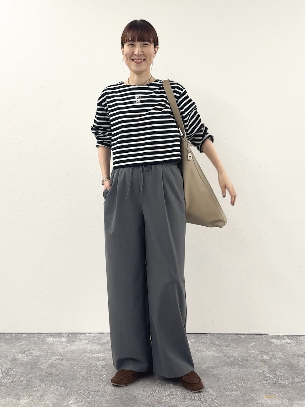 ブラック系のTシャツ/カットソー、ベージュ系のショルダーバッグ、グレー系のその他パンツを着用したレディースの秋コーディネートの9枚目の写真