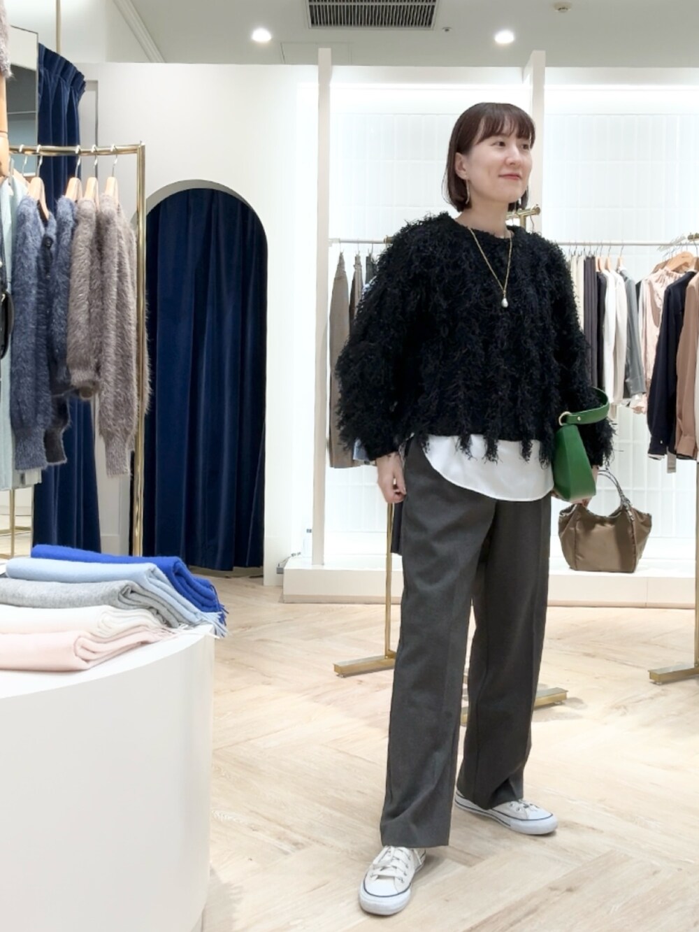 グレー系のその他パンツ、ホワイト系のシャツ/ブラウス、ブラック系のニット/セーターを着用したレディースの秋コーディネートの3枚目の写真