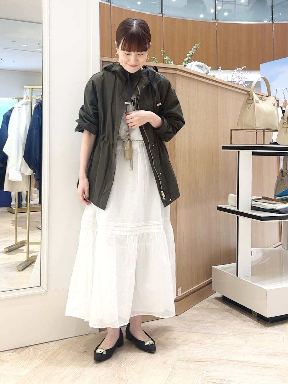 ブラウン系のショルダーバッグ、グレー系のブルゾン、ホワイト系のTシャツ/カットソーを着用したレディースの春コーディネートの8枚目の写真