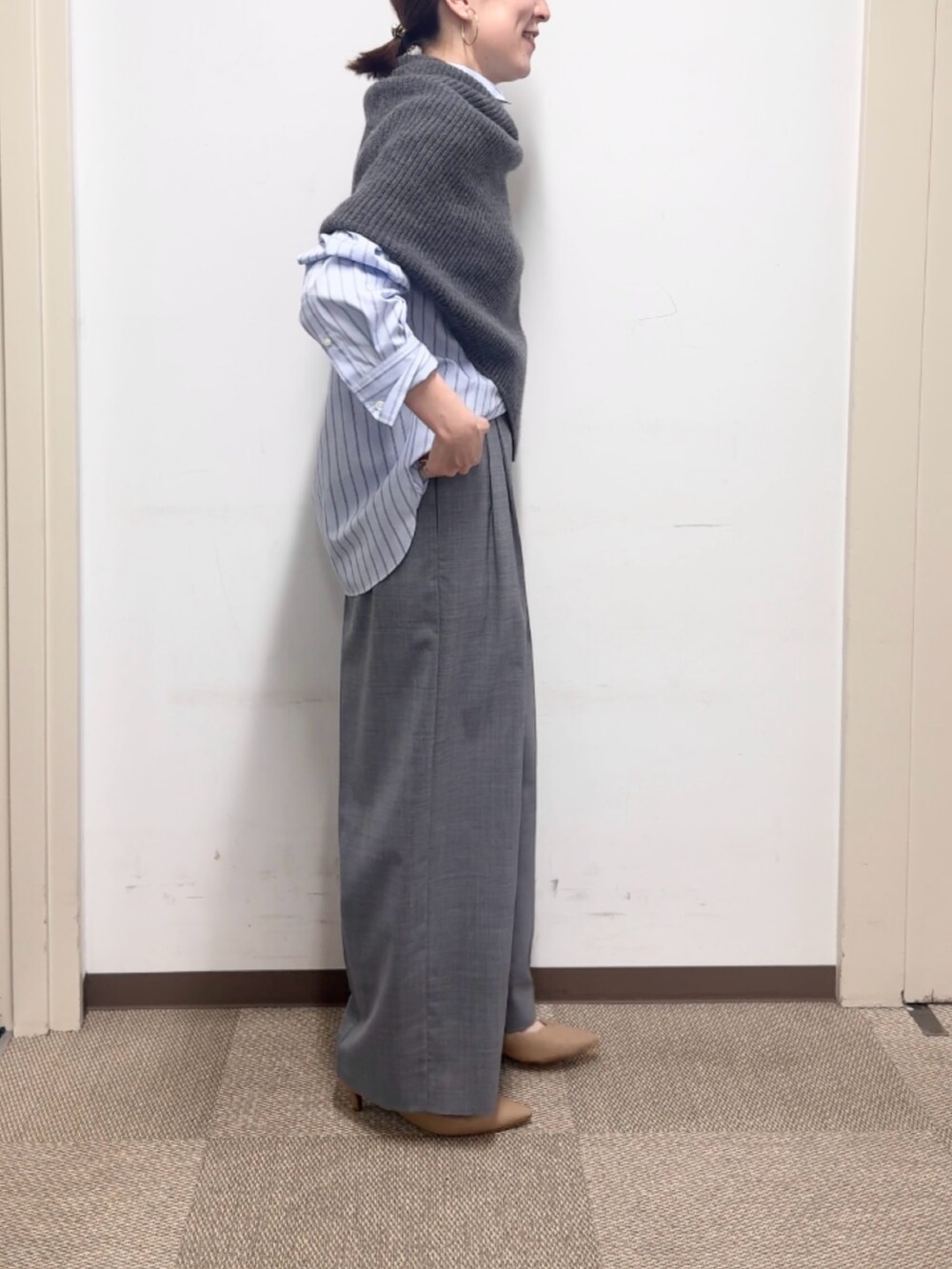 グレー系のニット/セーター、グレー系のその他パンツ、ブルー系のシャツ/ブラウスを着用したレディースの秋コーディネートの5枚目の写真