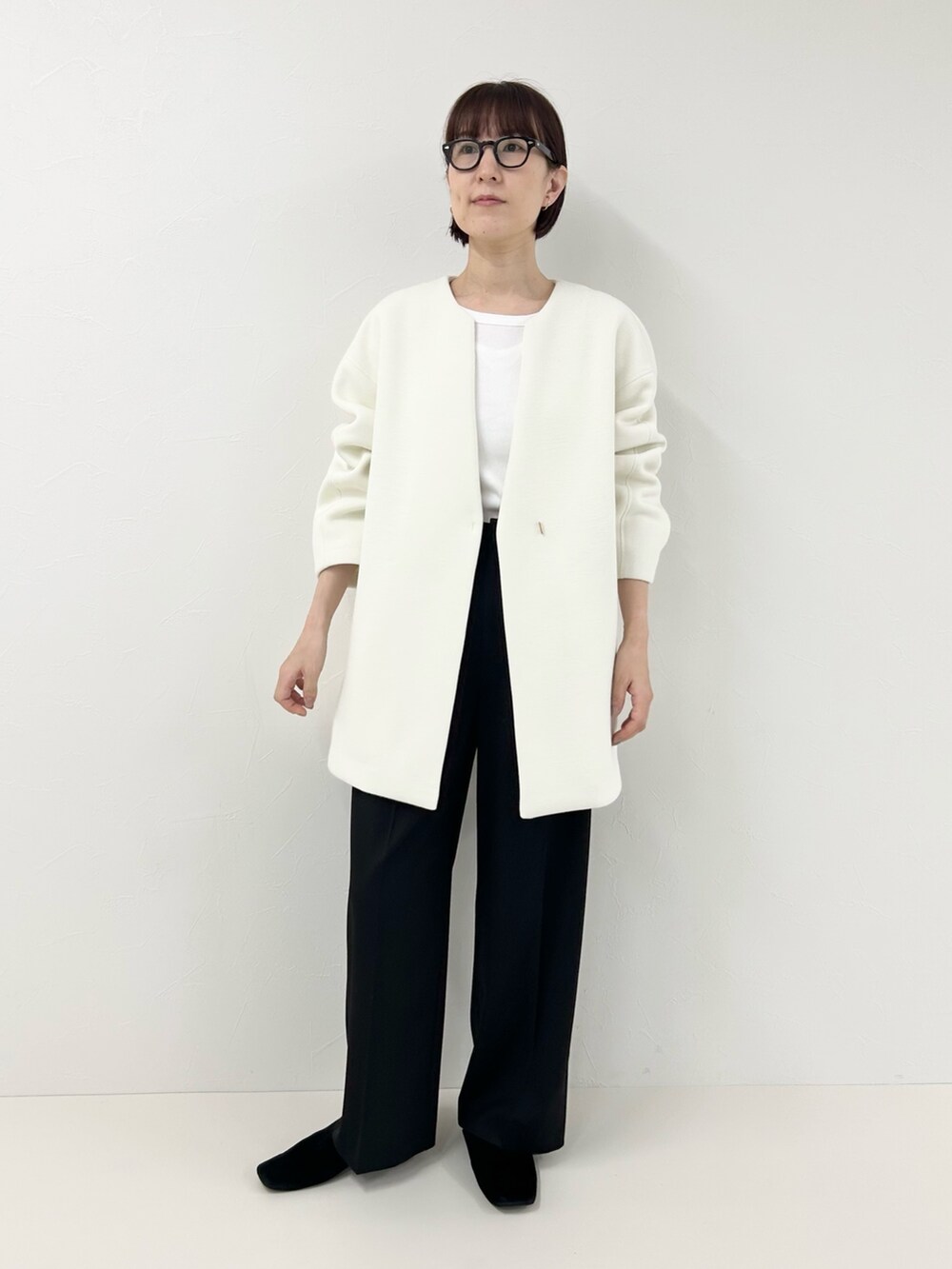 ホワイト系のTシャツ/カットソー、ブラック系のその他パンツ、ホワイト系のブルゾンを着用したレディースの冬コーディネートの4枚目の写真