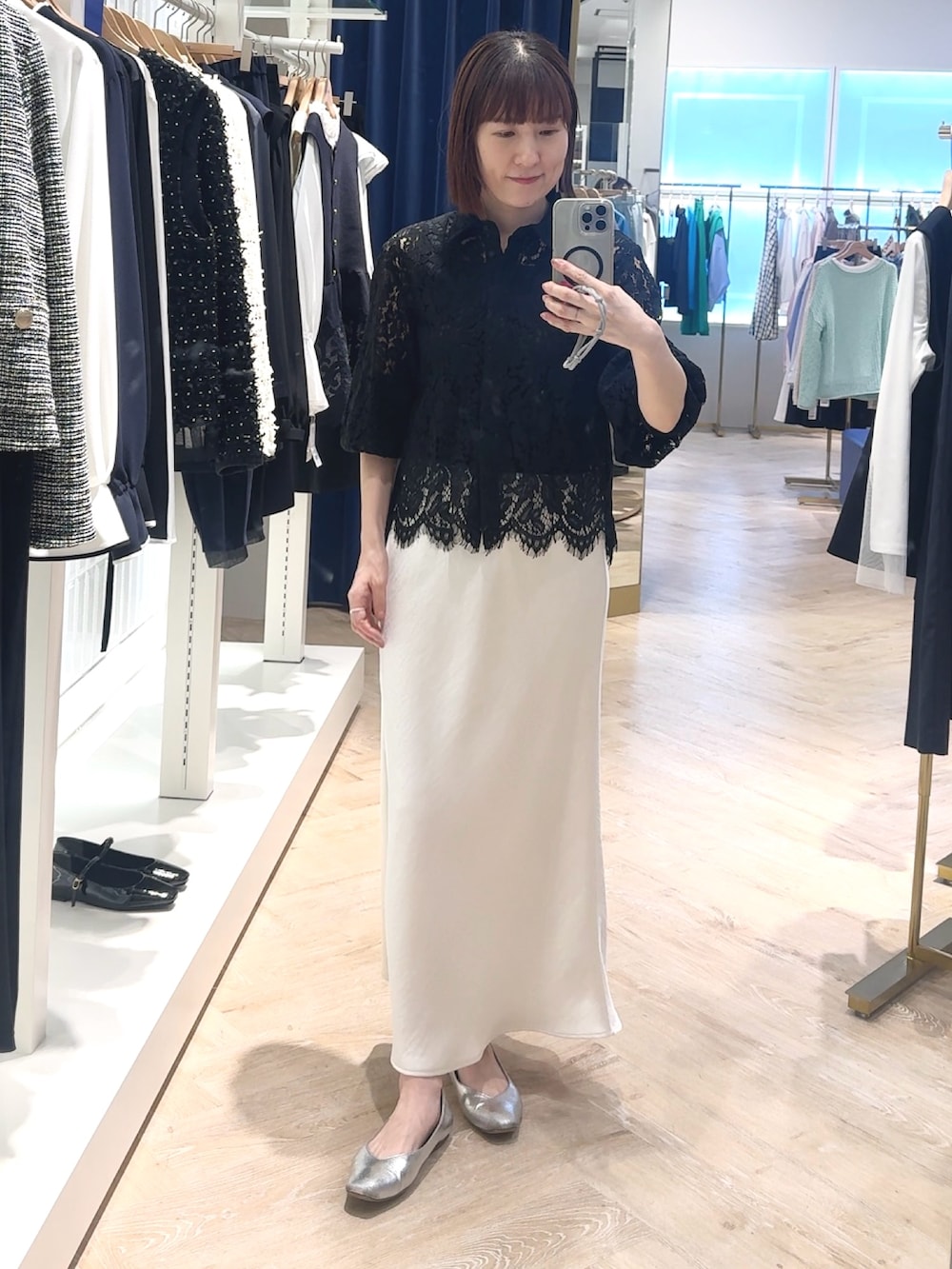 ホワイト系のスカート、ブラック系のシャツ/ブラウス、ブラック系のタンクトップを着用したレディースの春コーディネートの2枚目の写真