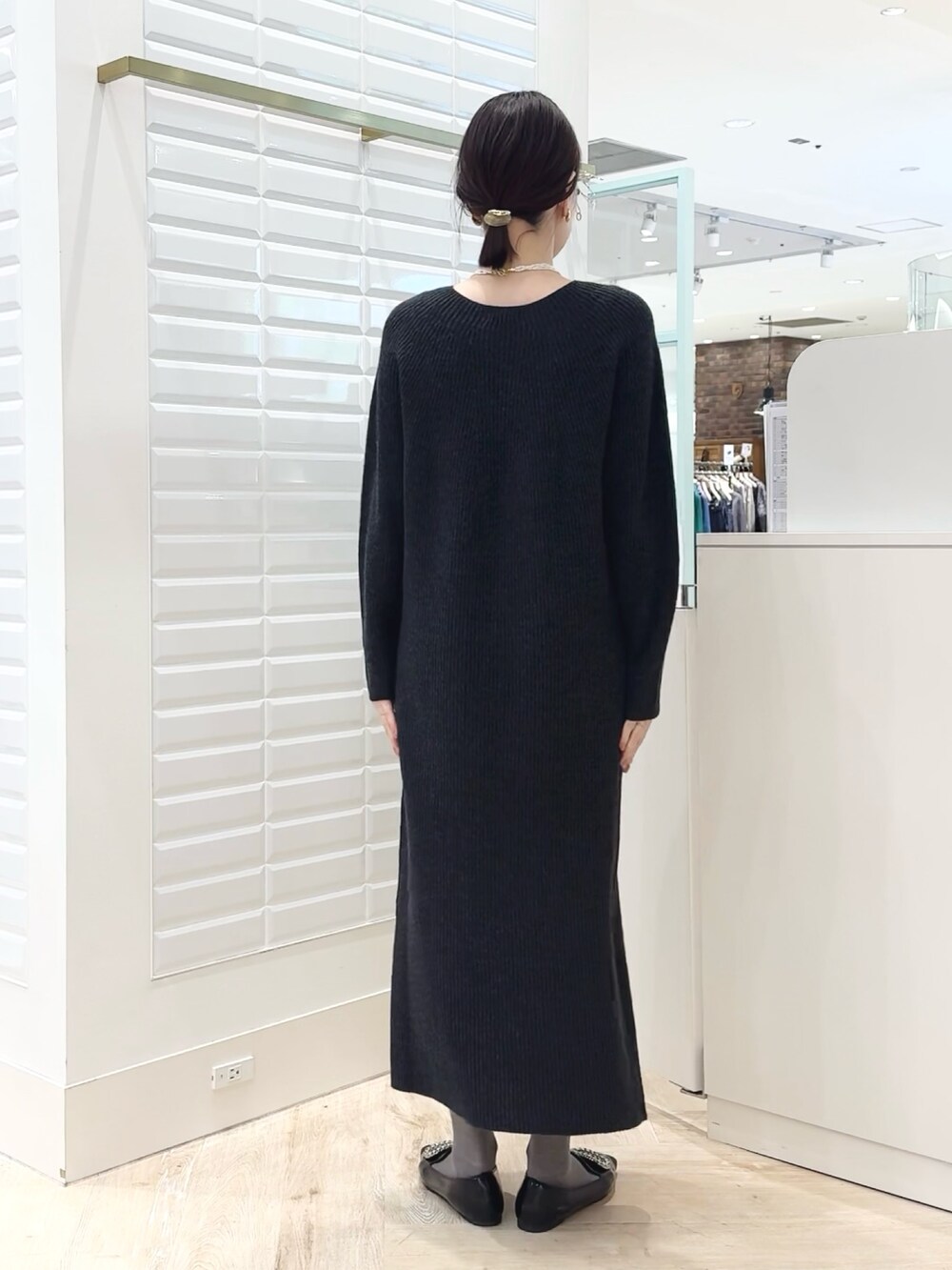 グレー系のワンピース、ゴールド系のイヤリング、ホワイト系のネックレスを着用したレディースの冬コーディネートの4枚目の写真