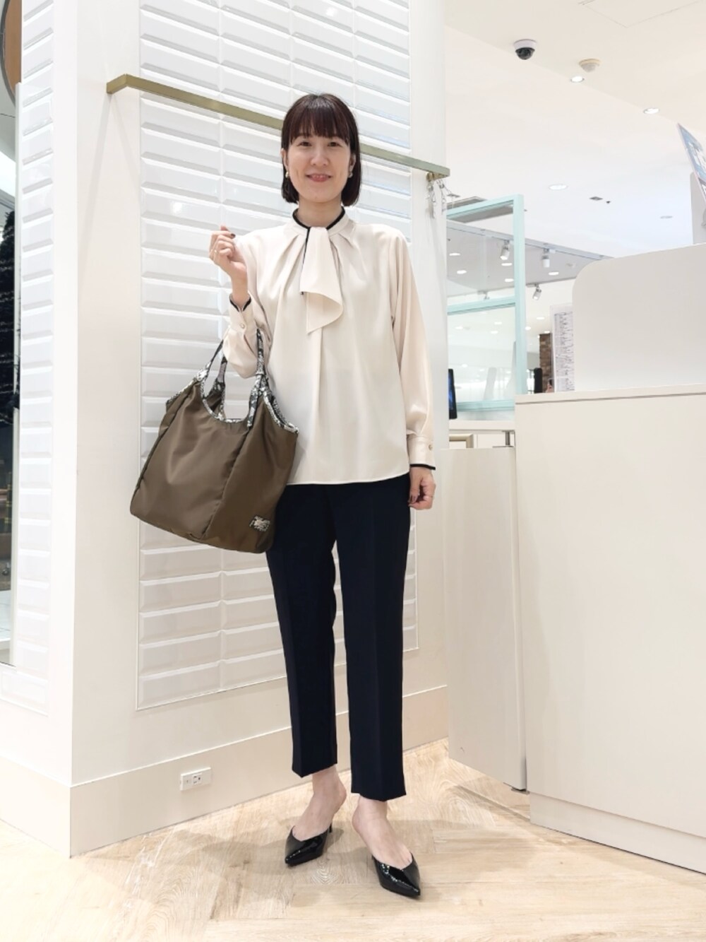 ブルー系のその他パンツ、ブラウン系のトートバッグ、ホワイト系のシャツ/ブラウスを着用したレディースの秋コーディネートの4枚目の写真