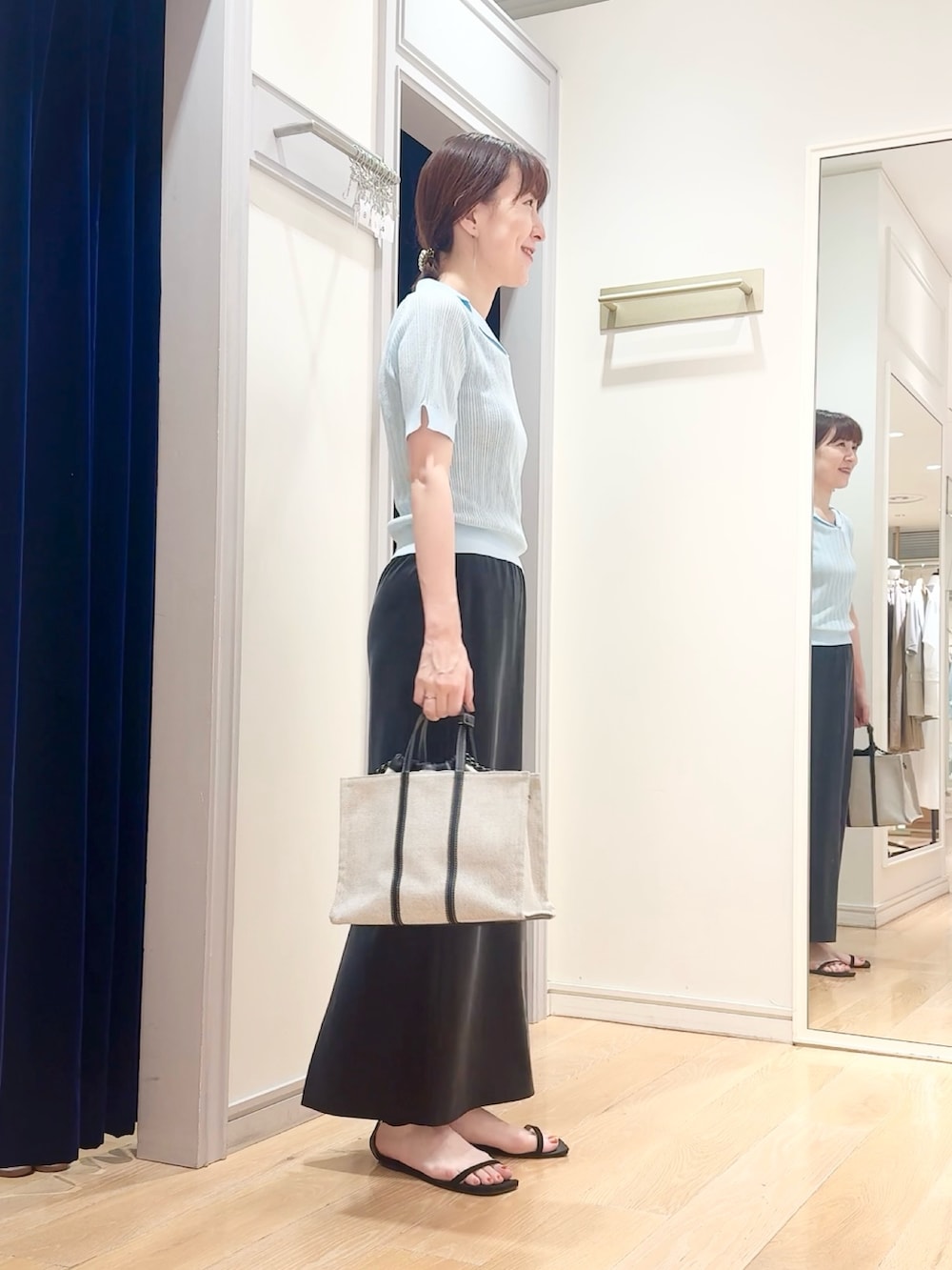 ブラック系のスカート、ベージュ系のタンクトップ、ブルー系のニット/セーターを着用したレディースの夏コーディネートの3枚目の写真