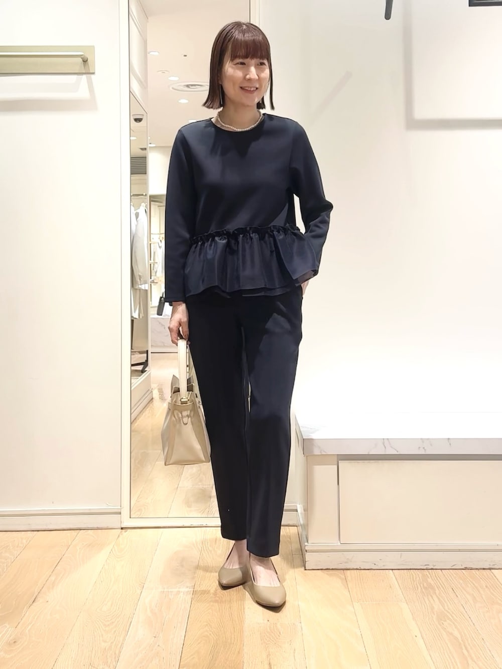 ベージュ系のトートバッグ、ブルー系のその他パンツ、ブルー系のTシャツ/カットソーを着用したレディースの春コーディネートの2枚目の写真