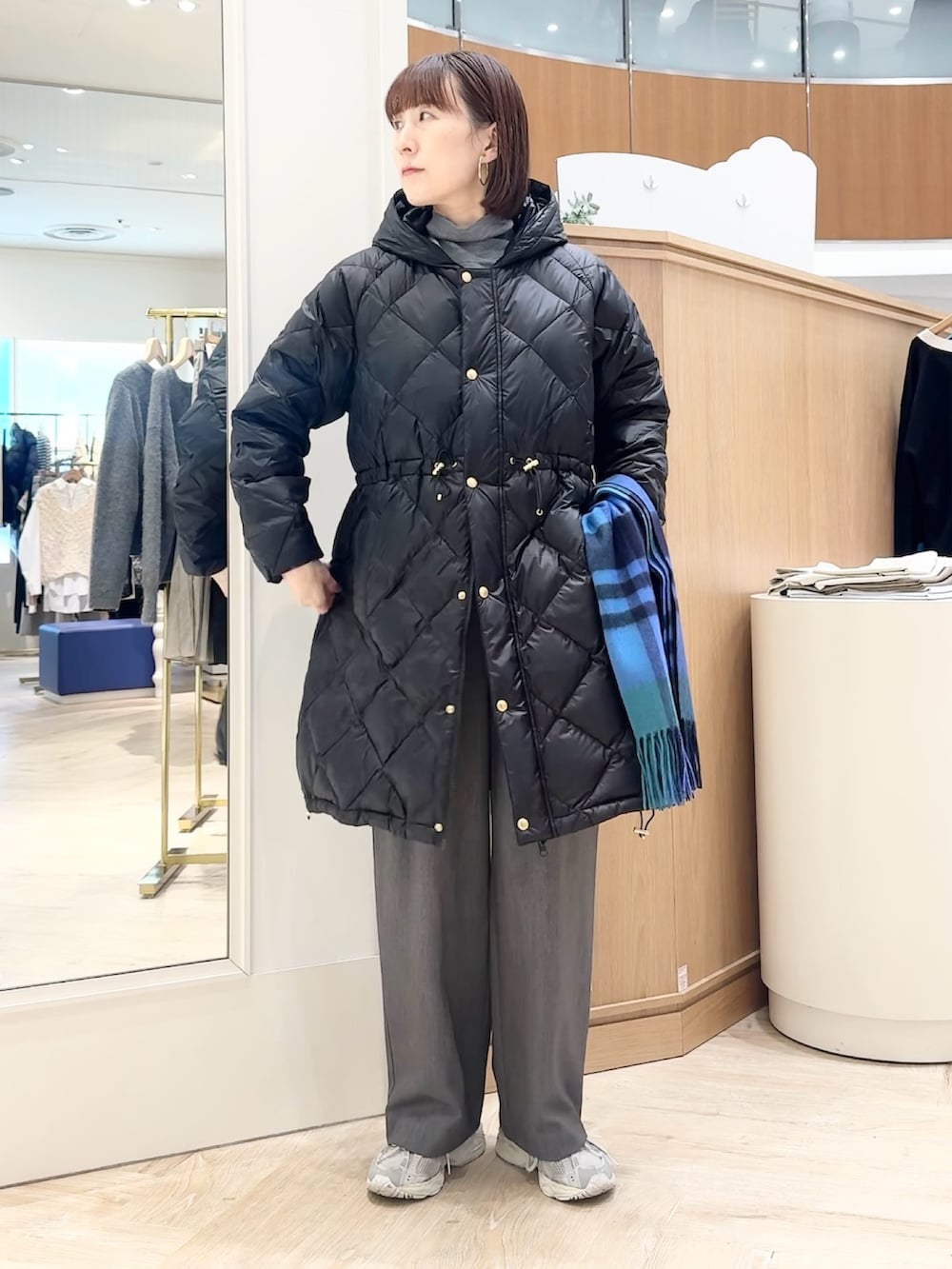 グレー系のその他パンツ、グレー系のニット/セーター、ブラック系のダウンジャケット/コートを着用したレディースの冬コーディネートの6枚目の写真