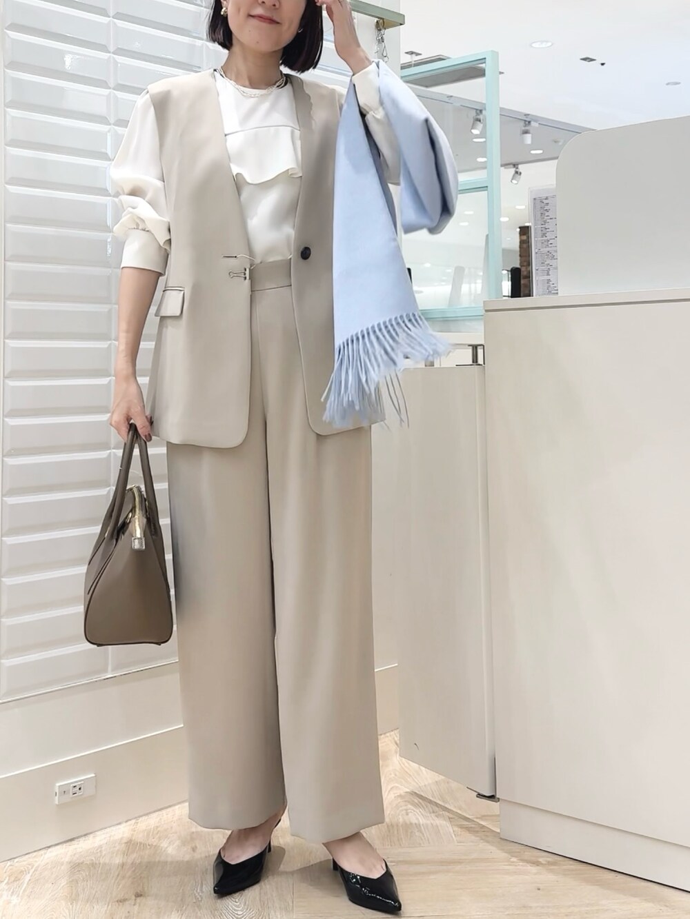 ブラウン系のショルダーバッグ、ベージュ系のその他パンツ、ベージュ系のベストを着用したレディースの秋コーディネートの3枚目の写真