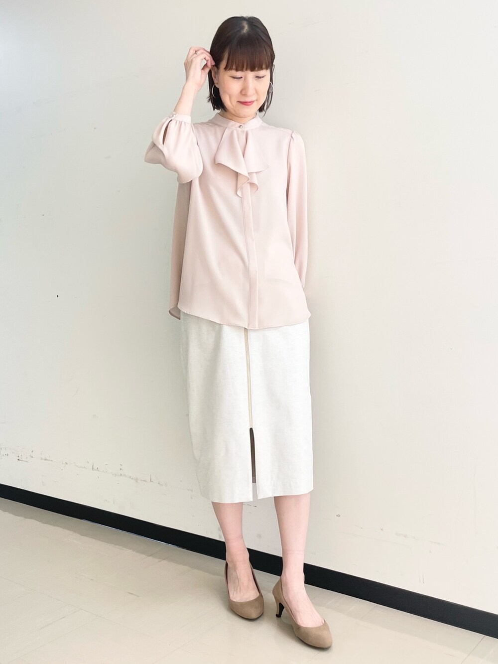 ベージュ系のスカート、ホワイト系のノーカラージャケット、ピンク系のシャツ/ブラウスを着用したレディースの春コーディネートの9枚目の写真
