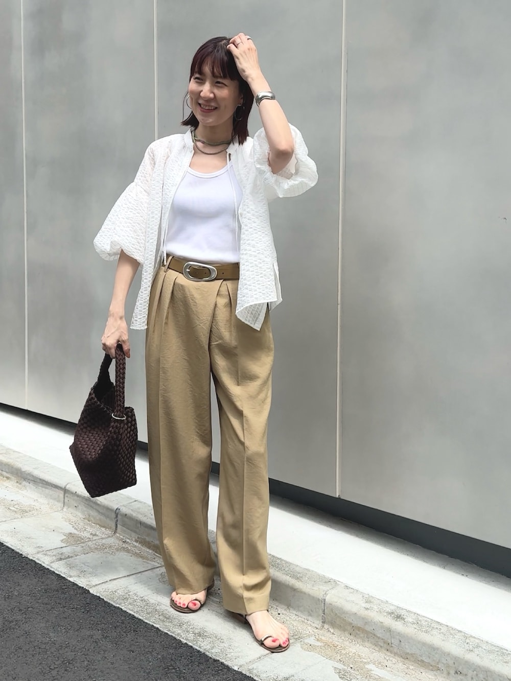 イエロー系のその他パンツ、ホワイト系のタンクトップ、ブラウン系のショルダーバッグを着用したレディースの夏コーディネートの3枚目の写真