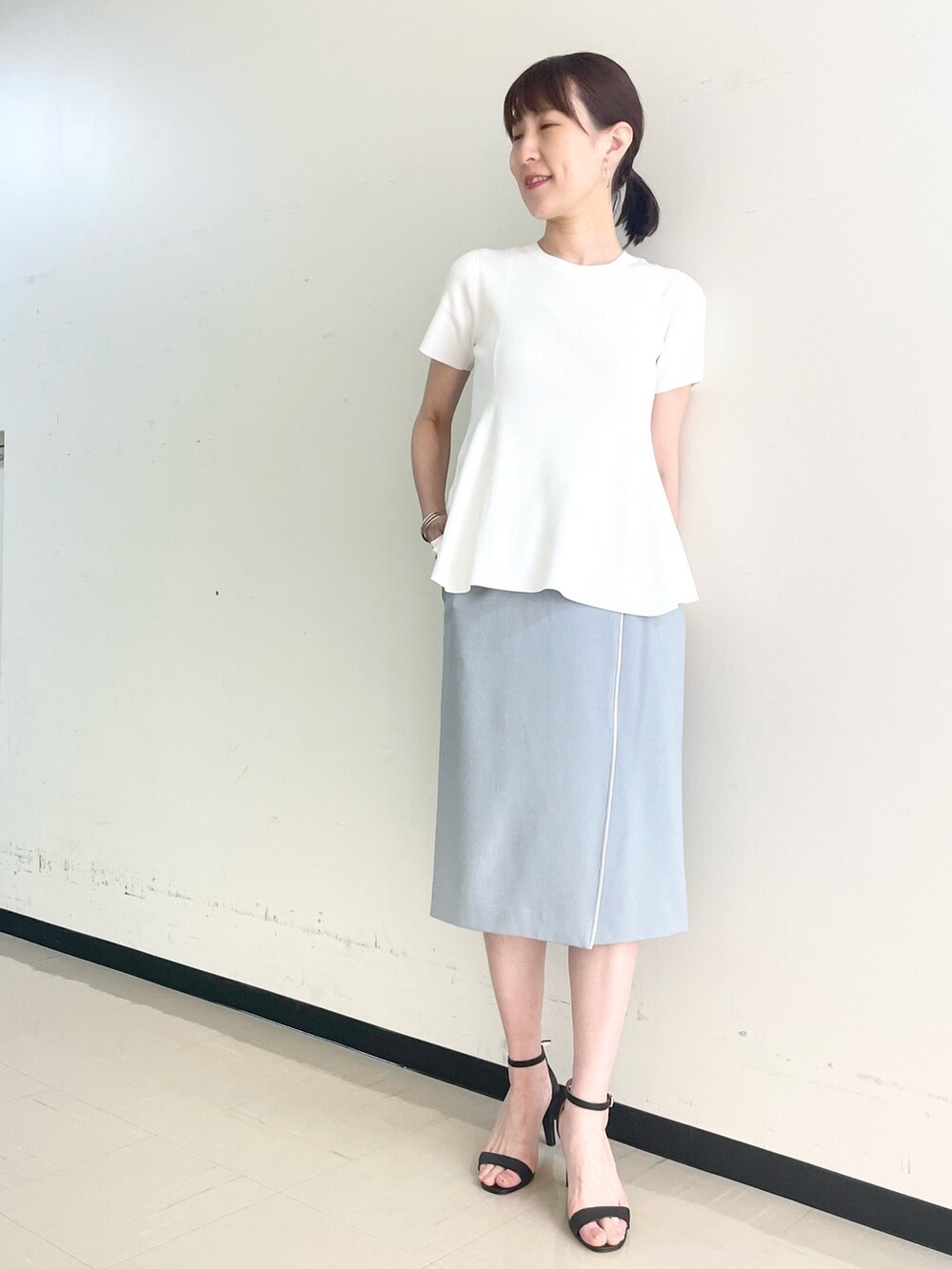 ブルー系のスカート、ホワイト系のニット/セーターを着用したレディースの春コーディネートの6枚目の写真