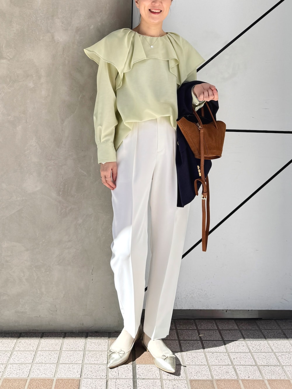 ホワイト系のその他パンツ、ブルー系のテーラードジャケット、イエロー系のトートバッグを着用したレディースの春コーディネートの8枚目の写真