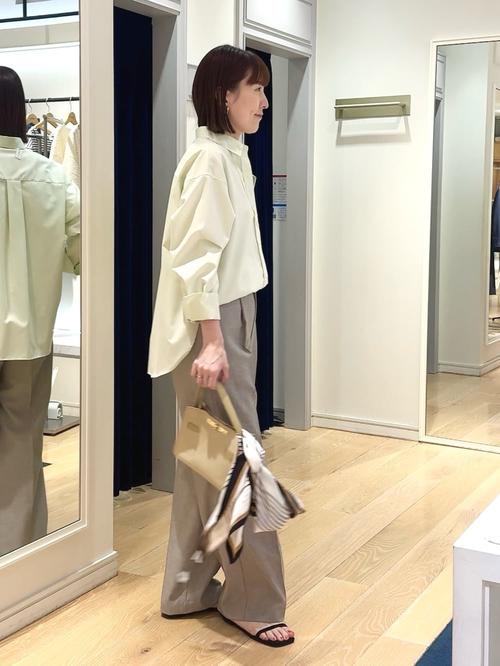 ベージュ系のその他パンツ、ベージュ系のトートバッグ、ホワイト系のシャツ/ブラウスを着用したレディースの春コーディネートの8枚目の写真