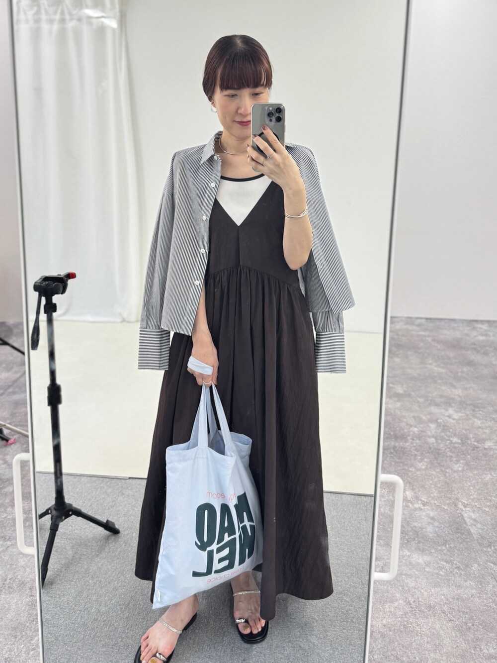 ブルー系のトートバッグ、シルバー系のサンダル、ブラウン系のワンピースを着用したレディースの夏コーディネートの6枚目の写真