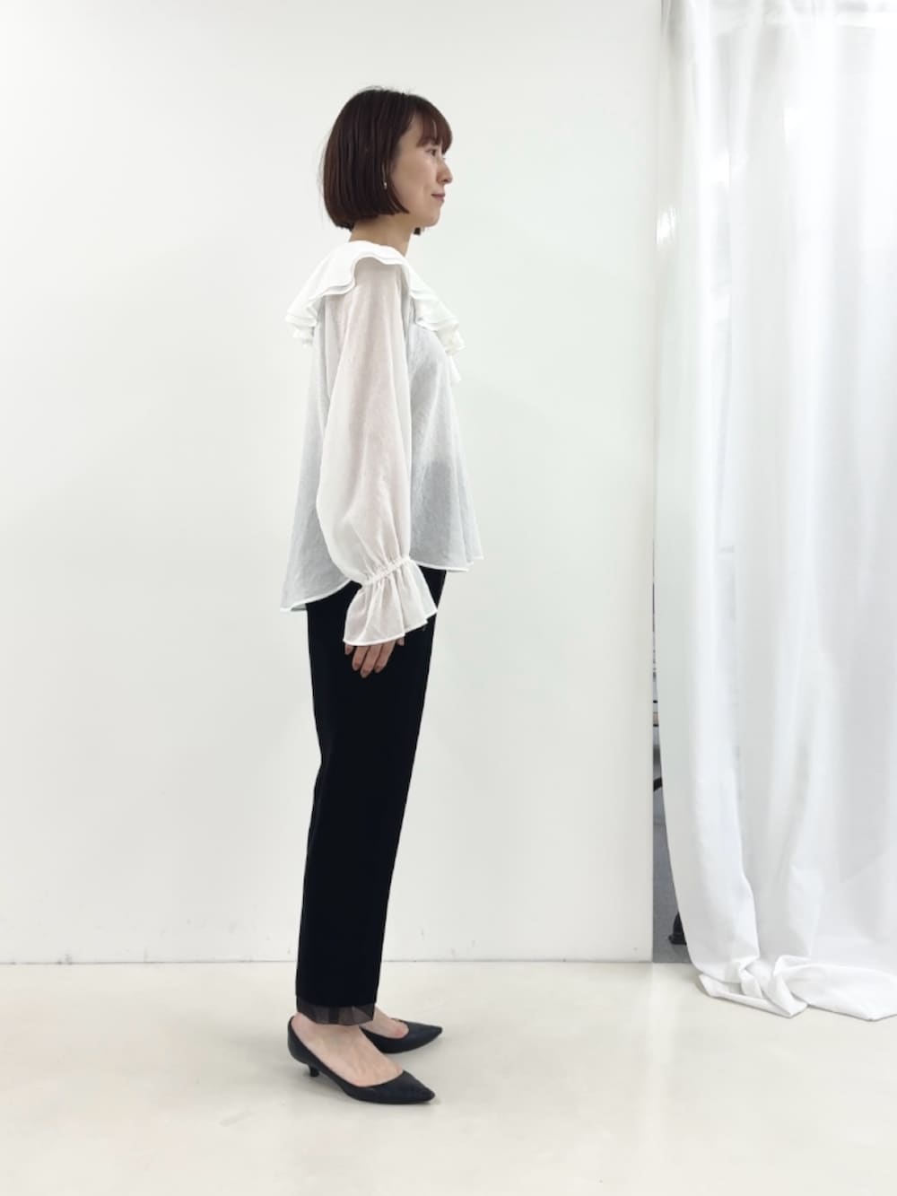 ブラック系のその他パンツ、ホワイト系のシャツ/ブラウスを着用したレディースの冬コーディネートの4枚目の写真