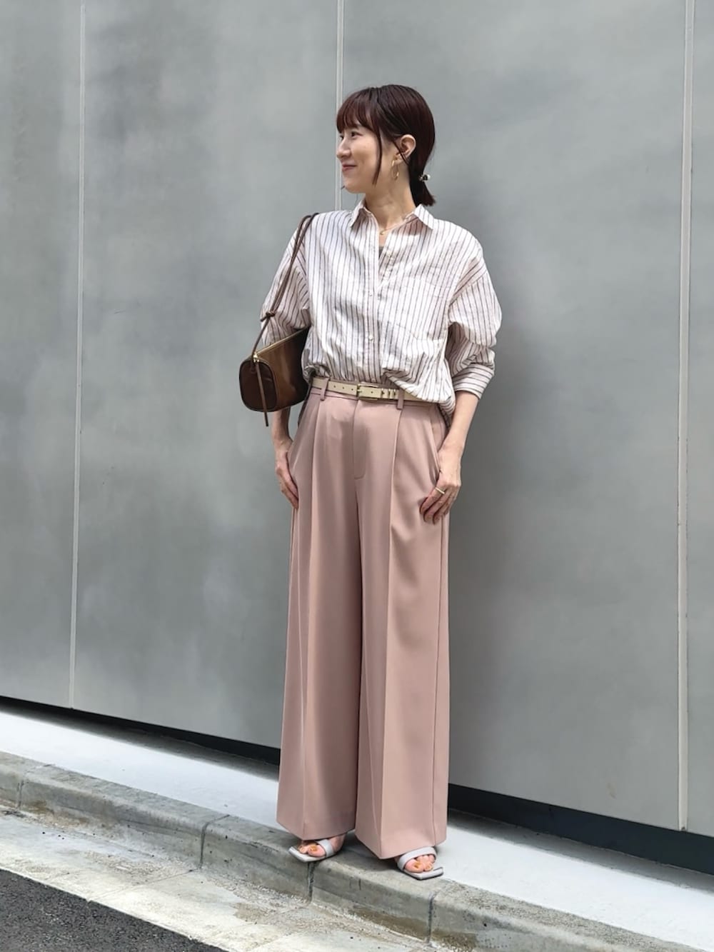 ピンク系のその他パンツ、ブラウン系のショルダーバッグ、ピンク系のシャツ/ブラウスを着用したレディースの春コーディネートの2枚目の写真