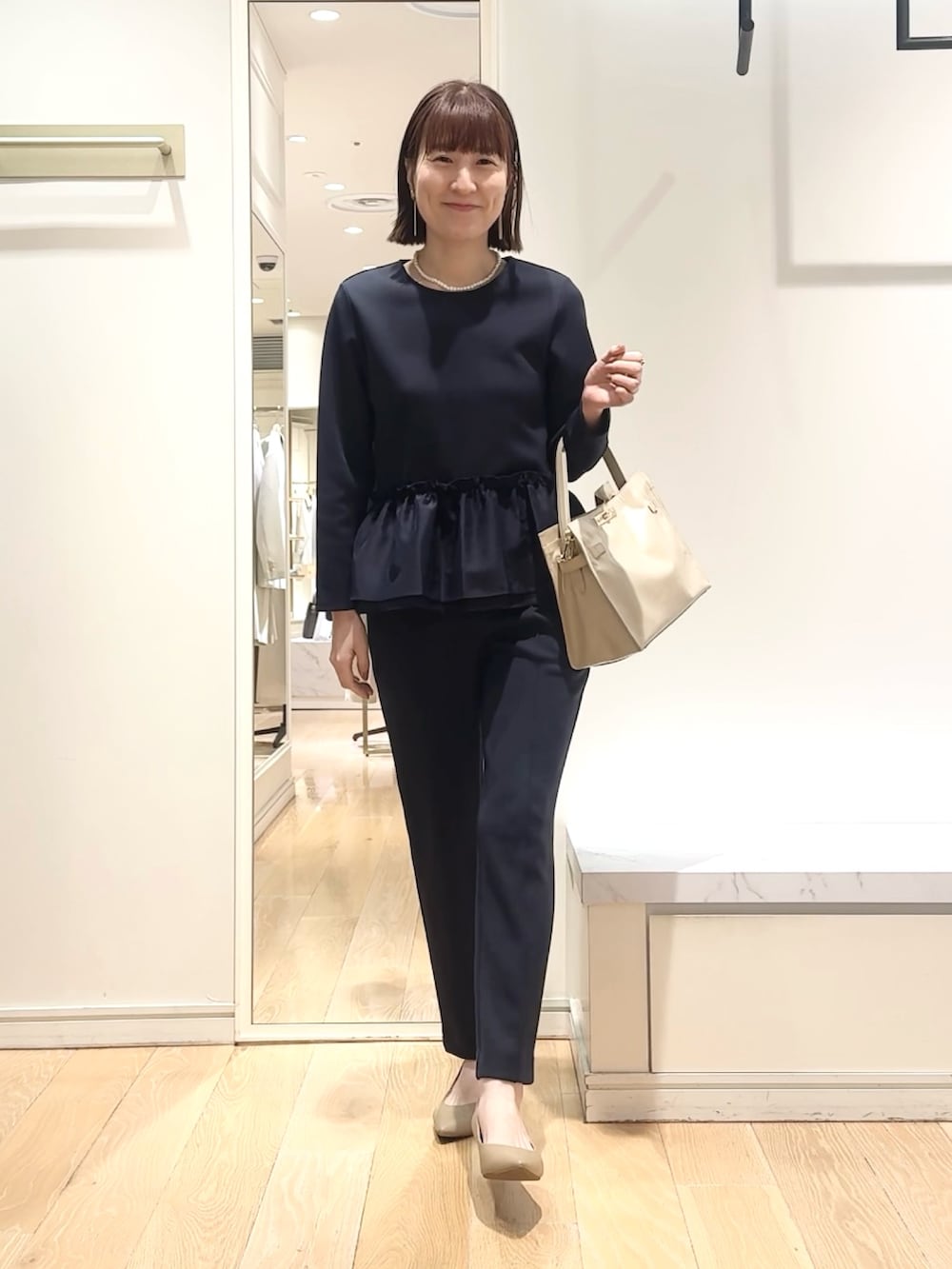 ベージュ系のトートバッグ、ブルー系のその他パンツ、ブルー系のTシャツ/カットソーを着用したレディースの春コーディネートの3枚目の写真