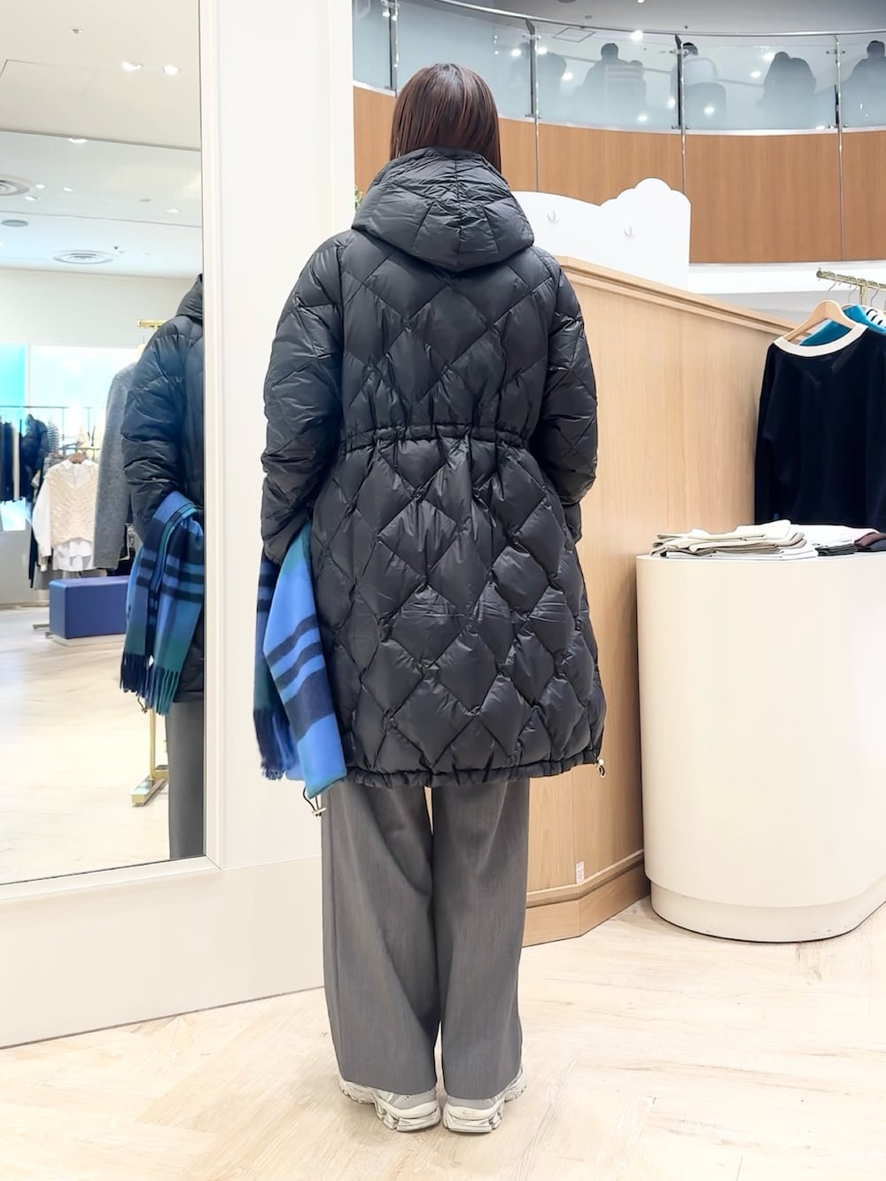 グレー系のその他パンツ、グレー系のニット/セーター、ブラック系のダウンジャケット/コートを着用したレディースの冬コーディネートの4枚目の写真