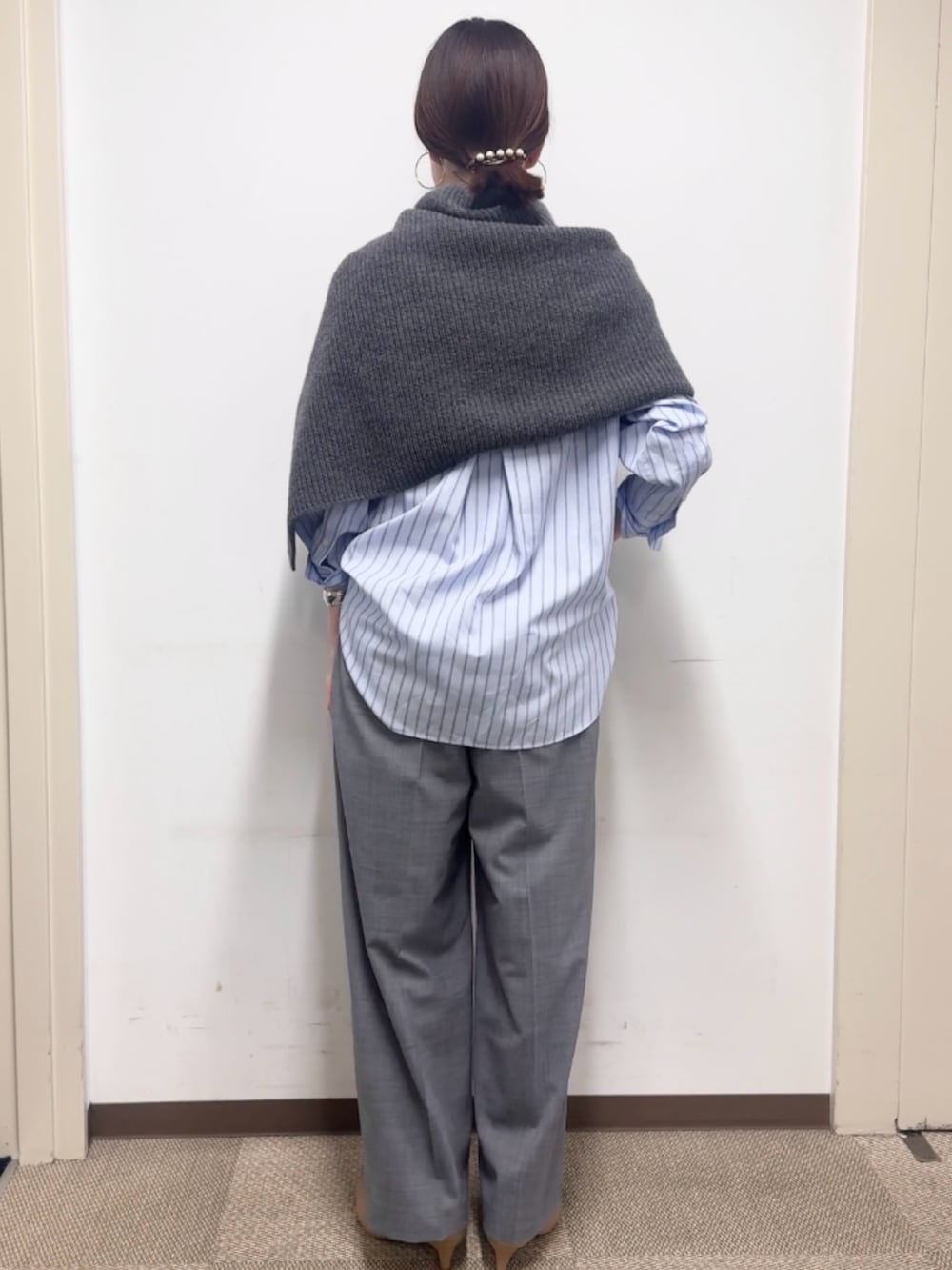 グレー系のニット/セーター、グレー系のその他パンツ、ブルー系のシャツ/ブラウスを着用したレディースの秋コーディネートの3枚目の写真