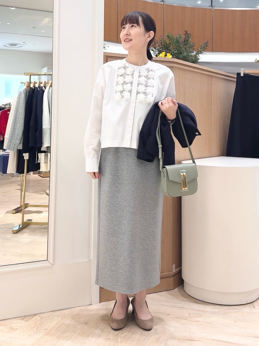 グレー系のスカート、ブルー系のブルゾン、ホワイト系のシャツ/ブラウスを着用したレディースの冬コーディネートの3枚目の写真