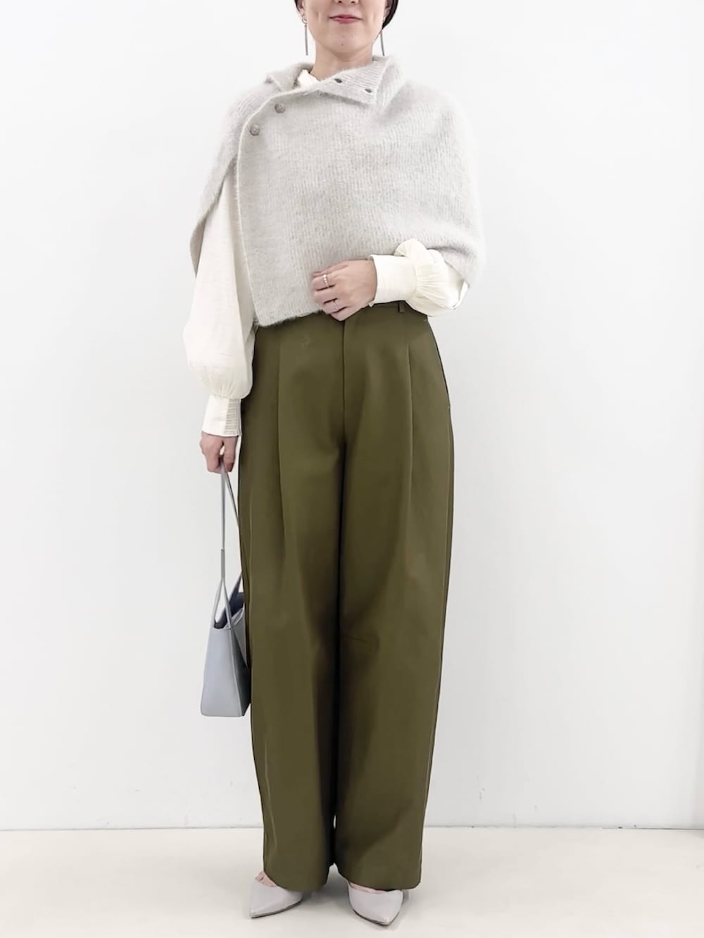 ブルー系のショルダーバッグ、グリーン系のチノパンツ、ホワイト系のシャツ/ブラウスを着用したレディースの秋コーディネートの3枚目の写真